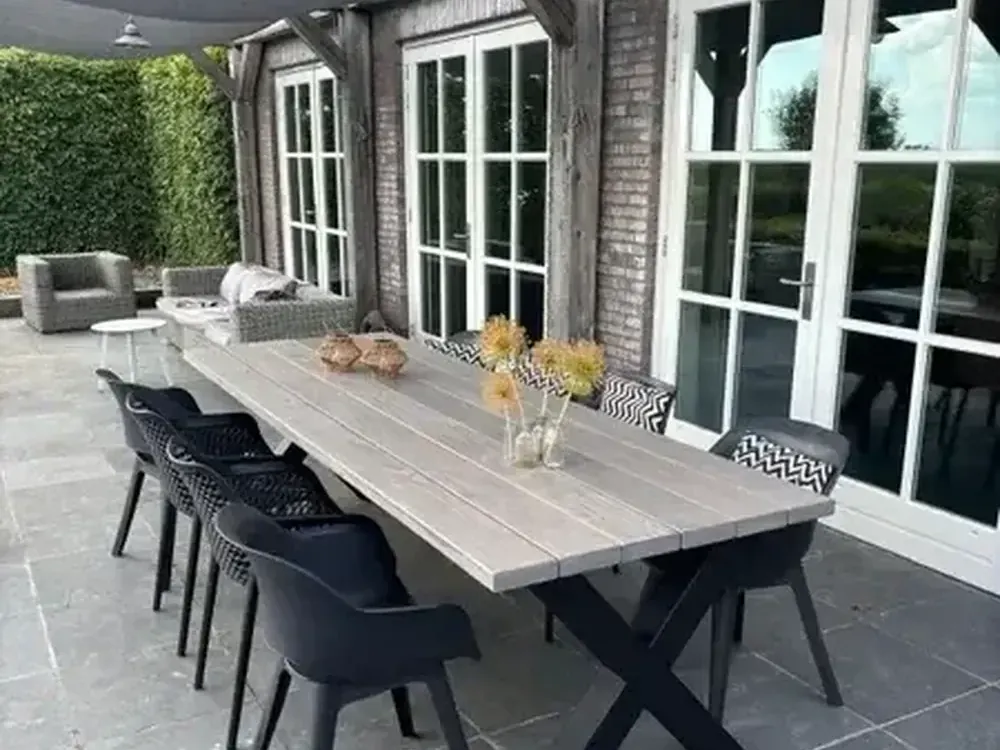 Lange douglas eettafel op maat onder een veranda, gemaakt door HOUT & HUIS werkplaats